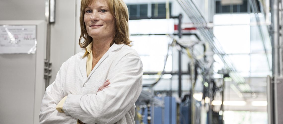 A portrait of a caucasian female technician in a technical research and development site.